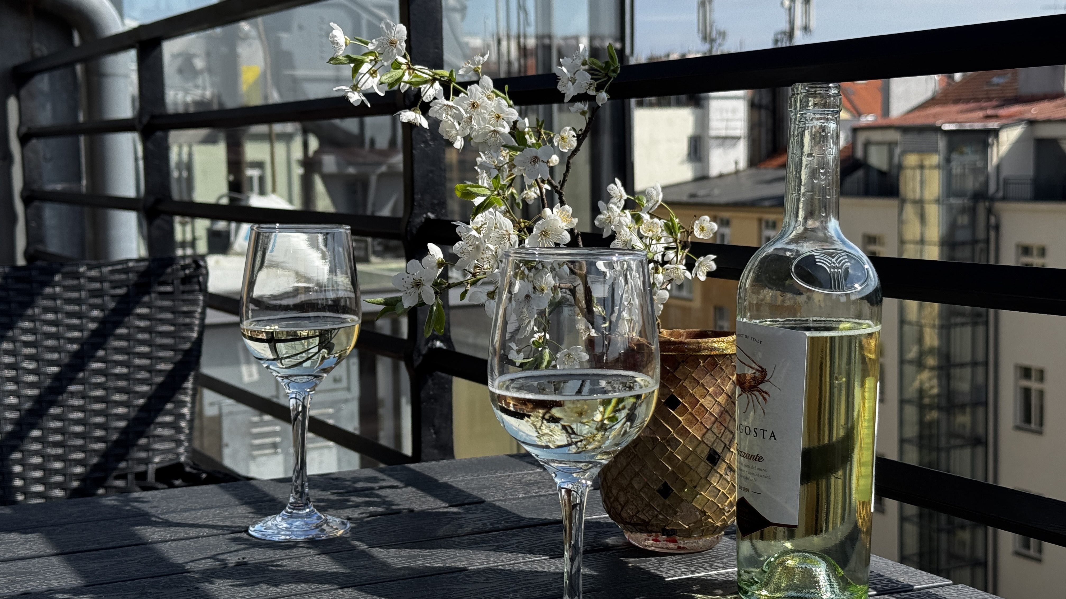 Close-up of a wine glass on the private terrace of Polska Penthouse, Vinohrady — an evening moment above the Prague rooftops