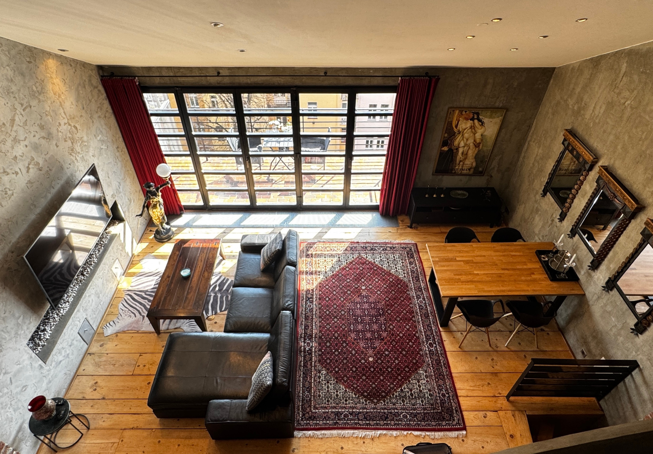 Indoor-outdoor terrace living space at Polska Penthouse — bifold glass doors opening to the Prague skyline and private garden