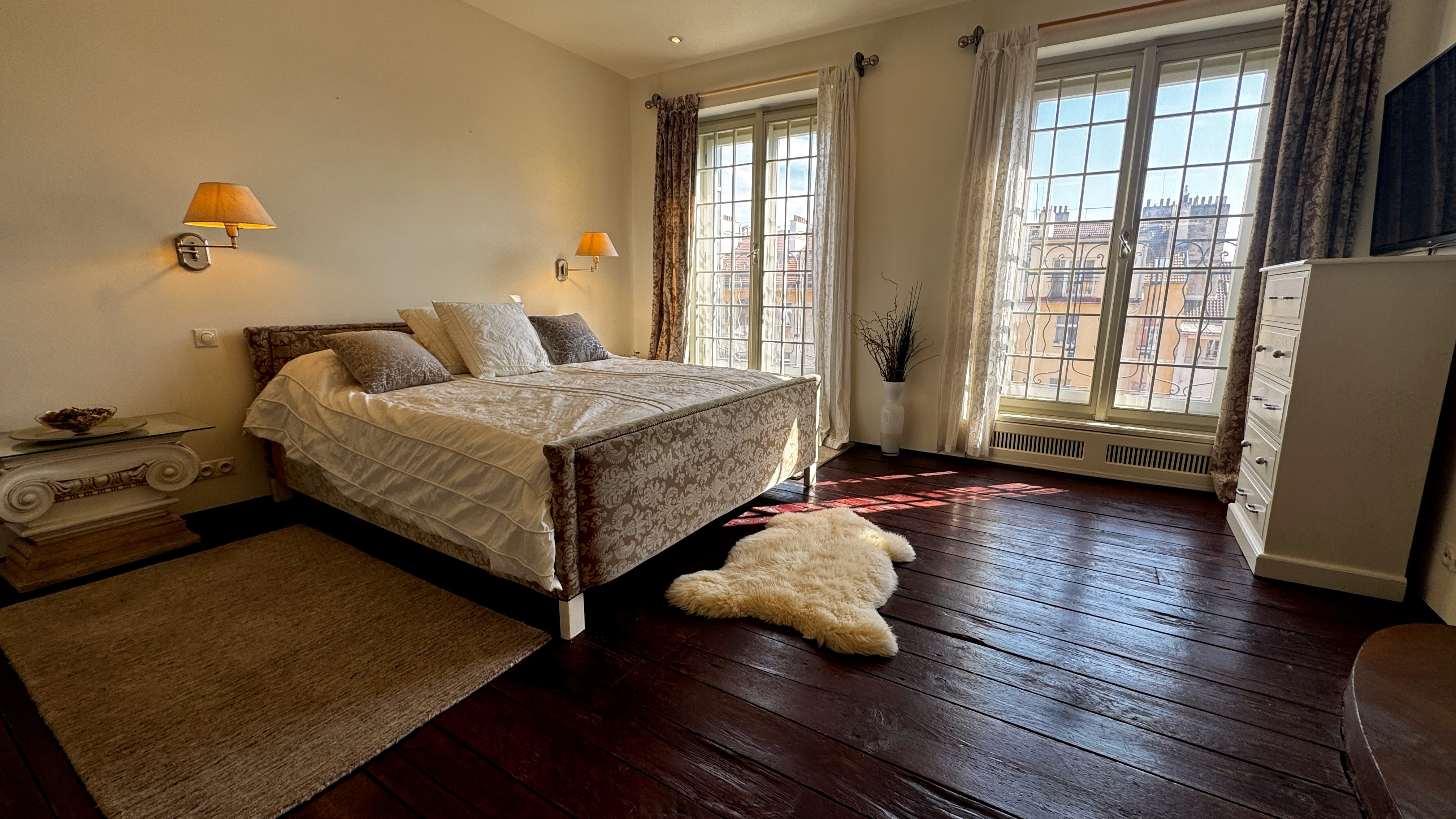 Neoclassical master bedroom at Polska Penthouse with early-twentieth-century style windows diffusing morning light across plastered walls