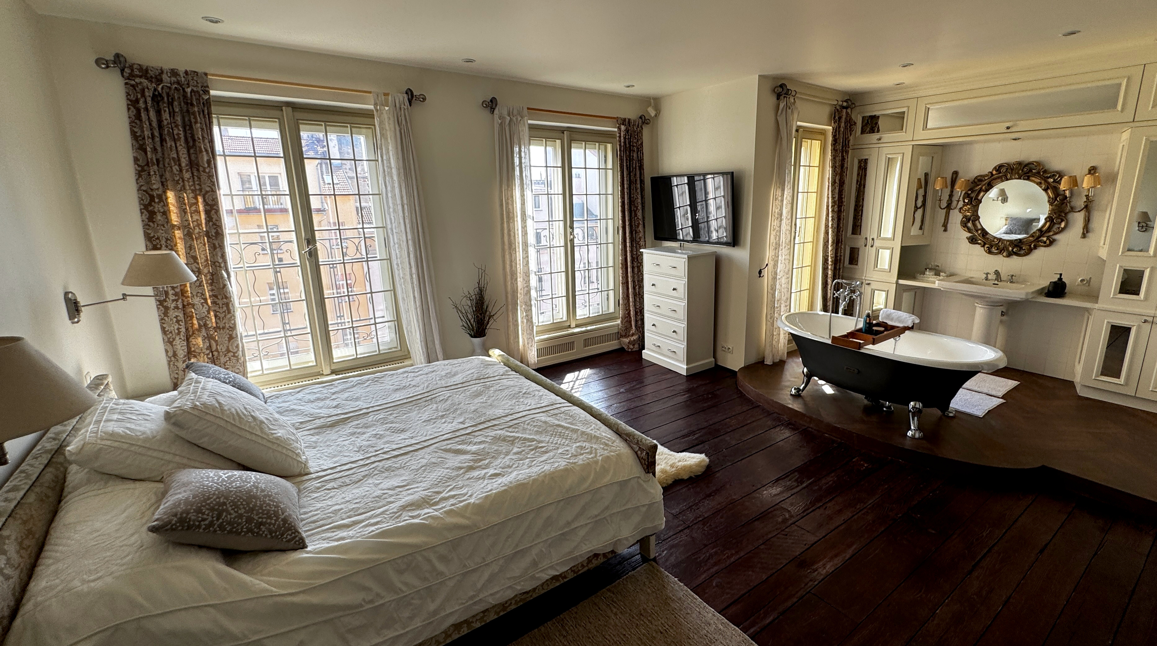 ROCA freestanding bathtub on a raised tiled platform in the master bathroom of Polska Penthouse, Vinohrady